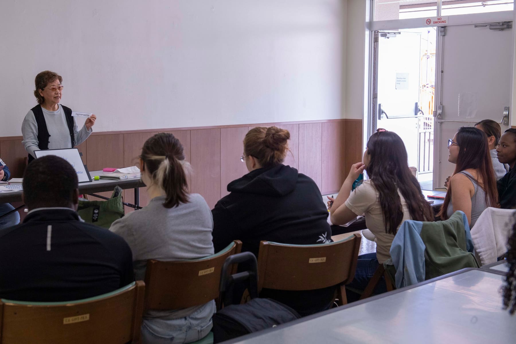 An instructor teaching a Japanese language class to adult learners
