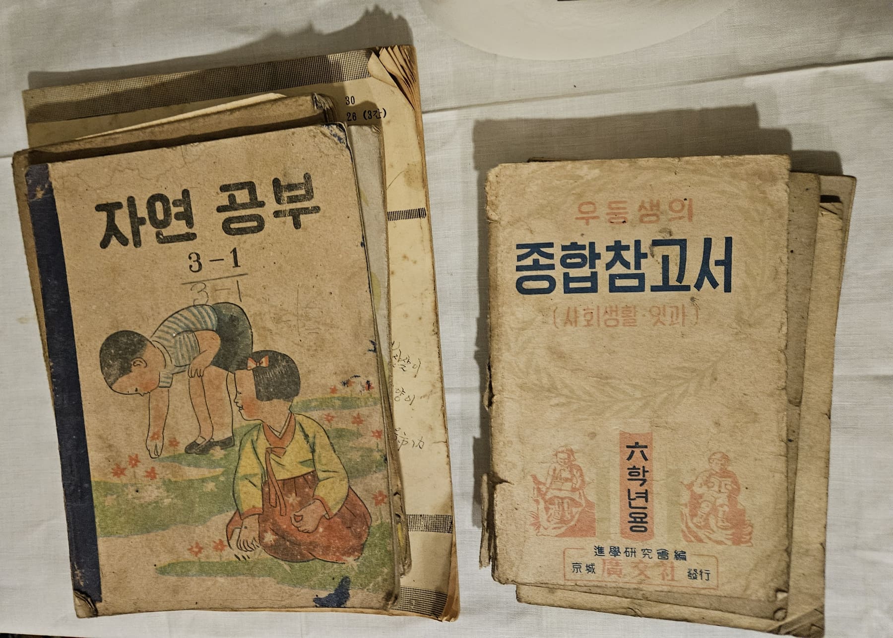 Old South Korean school textbooks with Hangul titles lying on a table